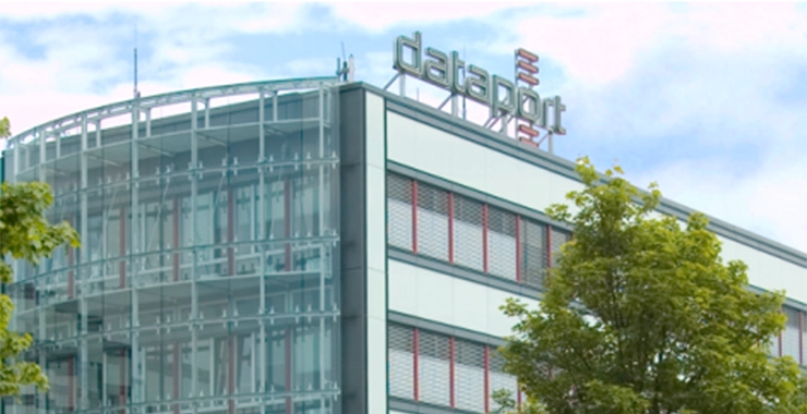 Gebäude mit „Dataport“-Schriftzug bei klarem Himmel, zwei Bäume im Vordergrund (Dataport).